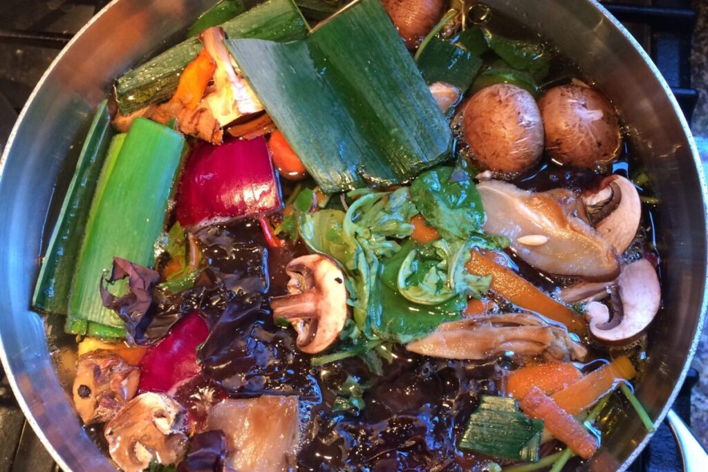 pot of soup with leeks, mushrooms, onions, carrots and water