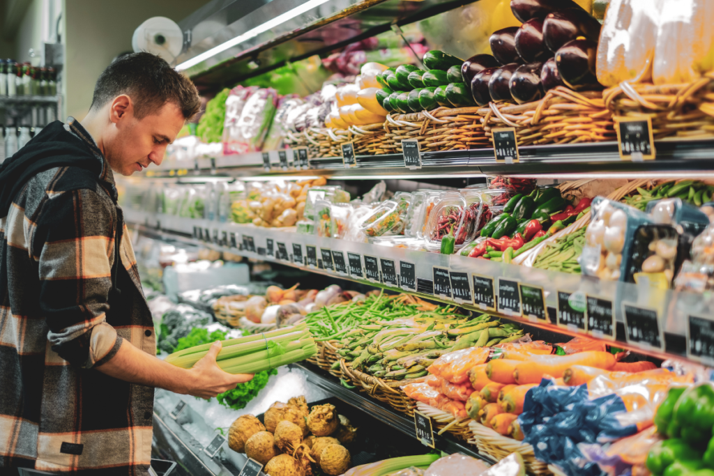 man buying celery in produce aisle