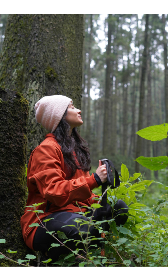 woman in front of tree in forest meditating